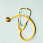 Estetoscopio sobre fondo amarillo simbolizando medicina prepaga y cuidado de la salud
