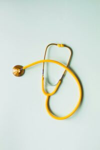 Estetoscopio sobre fondo amarillo simbolizando medicina prepaga y cuidado de la salud