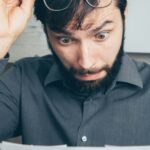 hombre leyendo sorprendido factura de aumento de prepaga cobermed